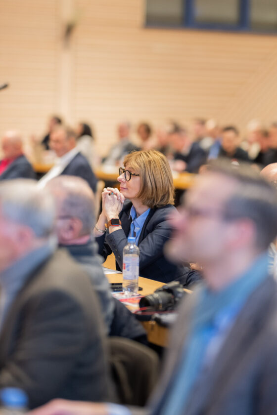 Woman listens attentively during conference.