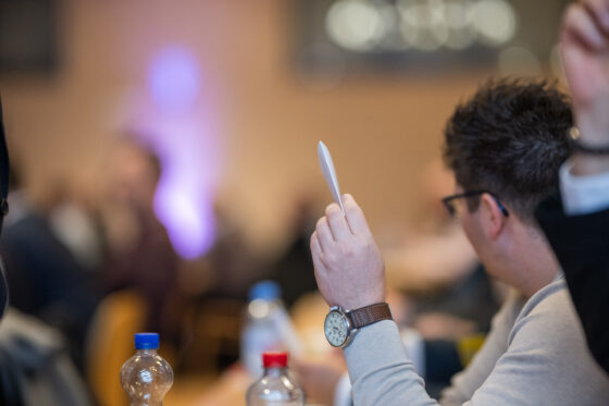 Person raises hand in meeting