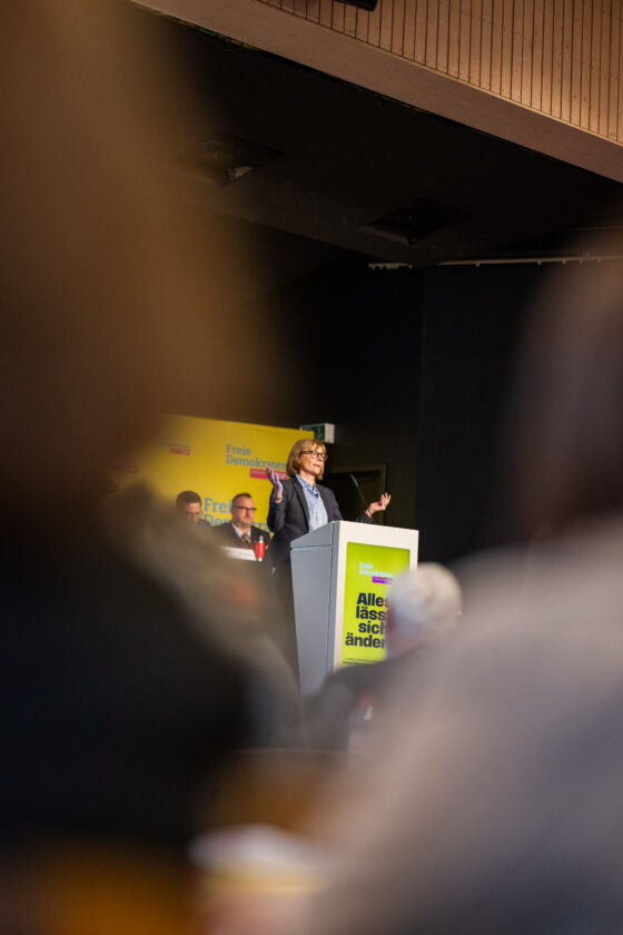 Woman gives speech at conference with FDP logo.