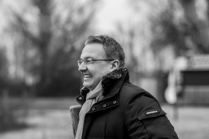 Smiling man in a winter coat outdoors.