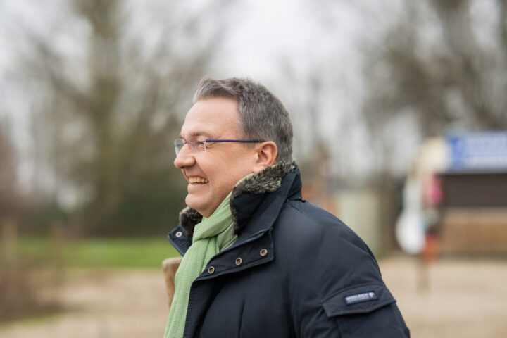 Laughing man with glasses and scarf outside