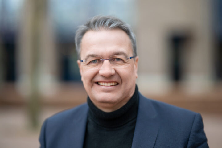 Smiling man with glasses outdoors