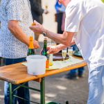 Menschen servieren Getränke bei einer Veranstaltung im Freien.
