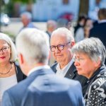 Menschen im Gespräch bei einer Veranstaltung im Freien.