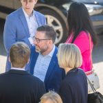 Personen unterhalten sich im Freien neben Auto