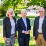 Drei Personen im Anzug im Freien