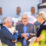 Drei Personen im Gespräch im Freien.