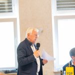 Älterer Mann spricht bei FDP-Veranstaltung mit Mikrofon.
