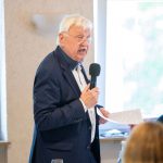 Mann hält Rede mit Mikrofon.