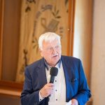 Älterer Mann hält Rede mit Mikrofon