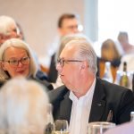 Personen bei einem formellen Treffen, lächelnd
